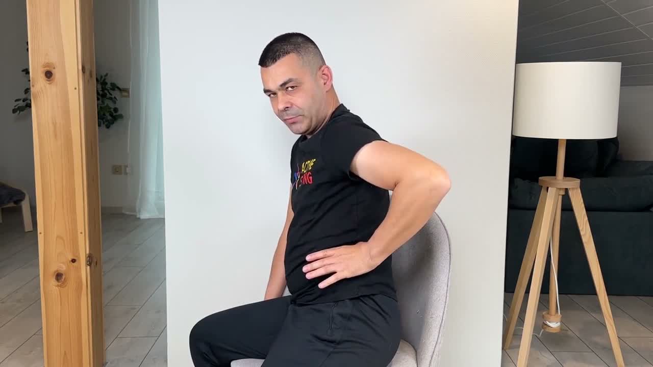 Conrad seated sideways, showing where to place his hand near the waist